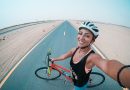 woman holding bicycle on asphalt road